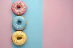 Glazed donuts with sprinkles lie on multi-colored background. With copy space. Photo from above