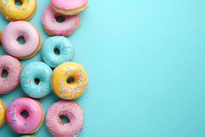 Glazed donuts with sprinkles lie on colored background. With copy space. Photo from above