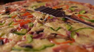 Close-up slow motion footage of large delicious pizza in greek tavern. Table setting. Customer service. Pizza with different toppings for a group of people. Mushrooms, piper, cheese, ham video