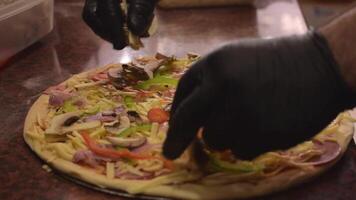 Koch tragen schwarz Handschuhe setzt Pilze auf zu ein Pizza. Konzept von Kochen köstlich Pizza. Schritt durch Schritt. Schritt 7. Nahansicht Schuss. schleppend Bewegung video