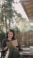 Attractive young lady in casual clothing is reading book sitting in cafe relaxing. Millennials, modern lifestyle concept video