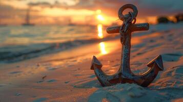 Anchor rests on sandy shore with sunset backdrop. photo