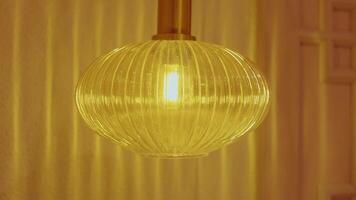 Close-up of a lit ribbed glass pendant light fixture video