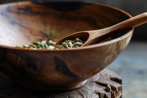 Bowl with grains cardamom detail of wooden spoon. photo