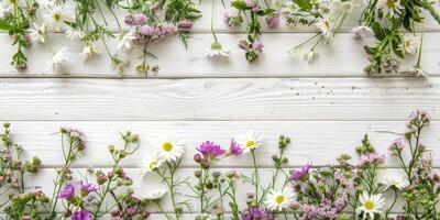 Assorted colorful flowers artistically arranged on rustic white wooden background photo