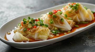 Boiled cabbage, adorned with chopped green onion, a small amount of sweet pepper, light soy sauce, oval shaped white plate. photo