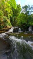 Smooth FPV flight over cascading river in a tropical rainforest in Thailand. video