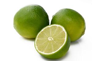 two limes and a green lime wedge on a white background 1 photo