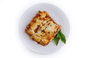 slice of lasagna with melted cheese on top and minced meat filling close-up isolated on white background with shadow 2 photo