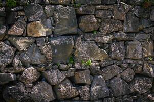 Granite stones of different shapes and colors. Wall cladding. photo