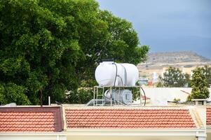A solar powered and ecological water heater on a roof of a house 2 photo