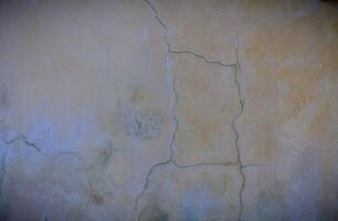 cracked concrete wall covered with gray cement surface as background photo