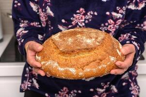 appetizing homemade whole grain bread in the hands of a woman 3 photo