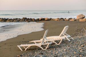 beach loungers in the setting sun in the evening 3 photo