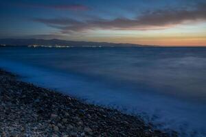 Sea shore area and horizon during sunset, blue hour. photo