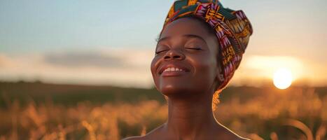 Woman In Colorful Headscarf Smiling In Golden Field At Sunset photo