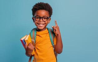 sonriente joven niña vistiendo lentes sostiene libro de texto en contra azul antecedentes foto