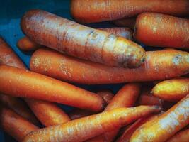 Pile of orange carrots in supermarket on the shelf. Food background photo