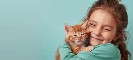 sonriente joven niña participación un jengibre gatito en contra un ligero azul antecedentes foto