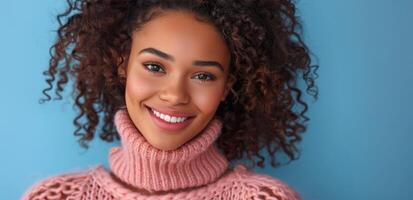 Woman With Curly Hair Smiling in Pink Sweater Against Blue Background photo