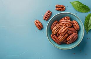 Bowl Filled With Nuts and Leaves on Blue Surface photo