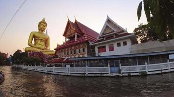 Bangkok, Thailand - 21st, march, 2024 - Big Buddha Wat Paknam at sunset. Chao Phraya river canal cruise. Tourists traveling by traditional boats. Thailand travel destinations video