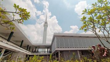 KUALA LUMPUR, MALAYSIA -17th april, 2024 - The National Mosque of Malaysia in Kuala Lumpur, Malaysia. Garden flowers, greenery and religious muslim walk in motion timelapse video