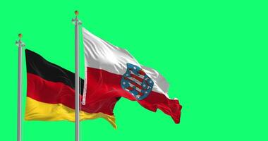 Thuringia and national german flags waving isolated on green background video