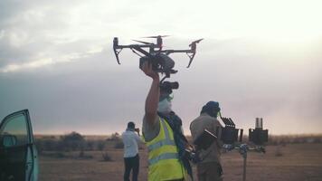 a man launches a drone with a camera into the air on the set of a film. launching a drone with a camera. filming in the desert. Movie production video