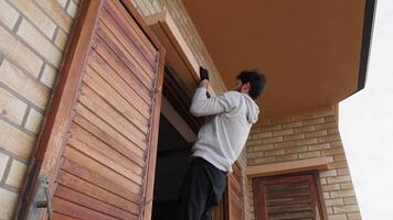 homem faz pull-ups exercícios em a janela às casa video