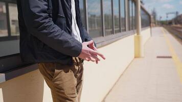 manos de joven hombre murga para tren en estación video