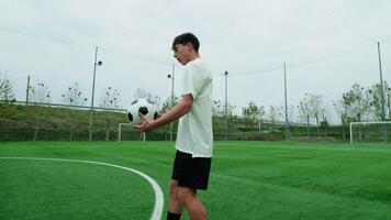 sportief tiener voetbal speler doet vrije stijl voetbal in de veld- video