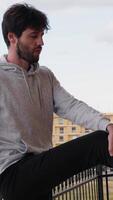 Young Man Stretches His Legs On Balcony At Home For Stretching Exercise video