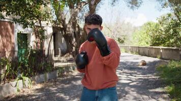 Young Boy Throws Punches With Boxing Gloves On A Country Road video