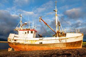 Middle-aged man playing captain on a boat stranded on an Icelandic beach photo