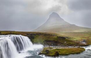 panoramic view of iconic kirkjufell mountain in iceland with waterfall in foreground photo