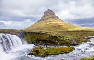 panoramic view of iconic kirkjufell mountain in iceland with waterfall in foreground photo