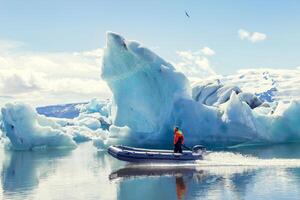 motor boat sailing on the azure waters between the icebergs photo