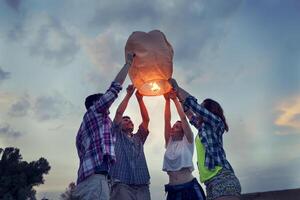 Group of young friends floating on a Chinese lantern photo