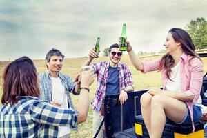 Happy group of young friends toasting with beer photo