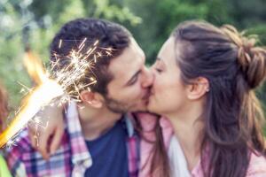 Pareja de amantes besos al aire libre en un verano puesta de sol foto