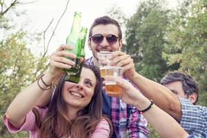 Happy group of young friends toasting with beer photo