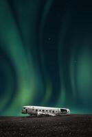 green northern lights over the wreck of a white airplane photo