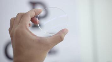 Hand holding glasses lenses in optical store video