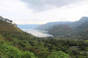 ver desde el mar en el borde de lago toba ciudad. alto calidad fotos