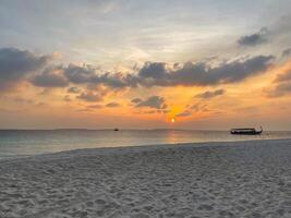 Sunset at the Maldives, boat and sand cost photo