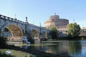 Rome, Italy - September 13 2022 Sant'Angelo Castel and Bridge with Boats. Castello Angelo and the Tiberis or Tevere River in Rome, Italy photo