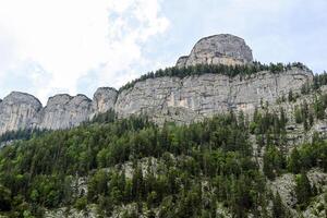 Steep Mountain Peak with Forest and Rocks photo