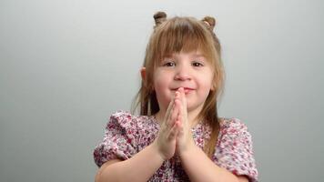 Background of children's emotions, a portrait of a girl clapping her hands. The girl applauds, dances and has fun, a cute happy smiling child. High quality 4k footage video