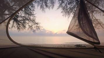 Open tent view from inside panoramic view to spectacular sunrise on the beach. First Person point of view rise early watch sunrise concept.Copy space relaxing camping background video